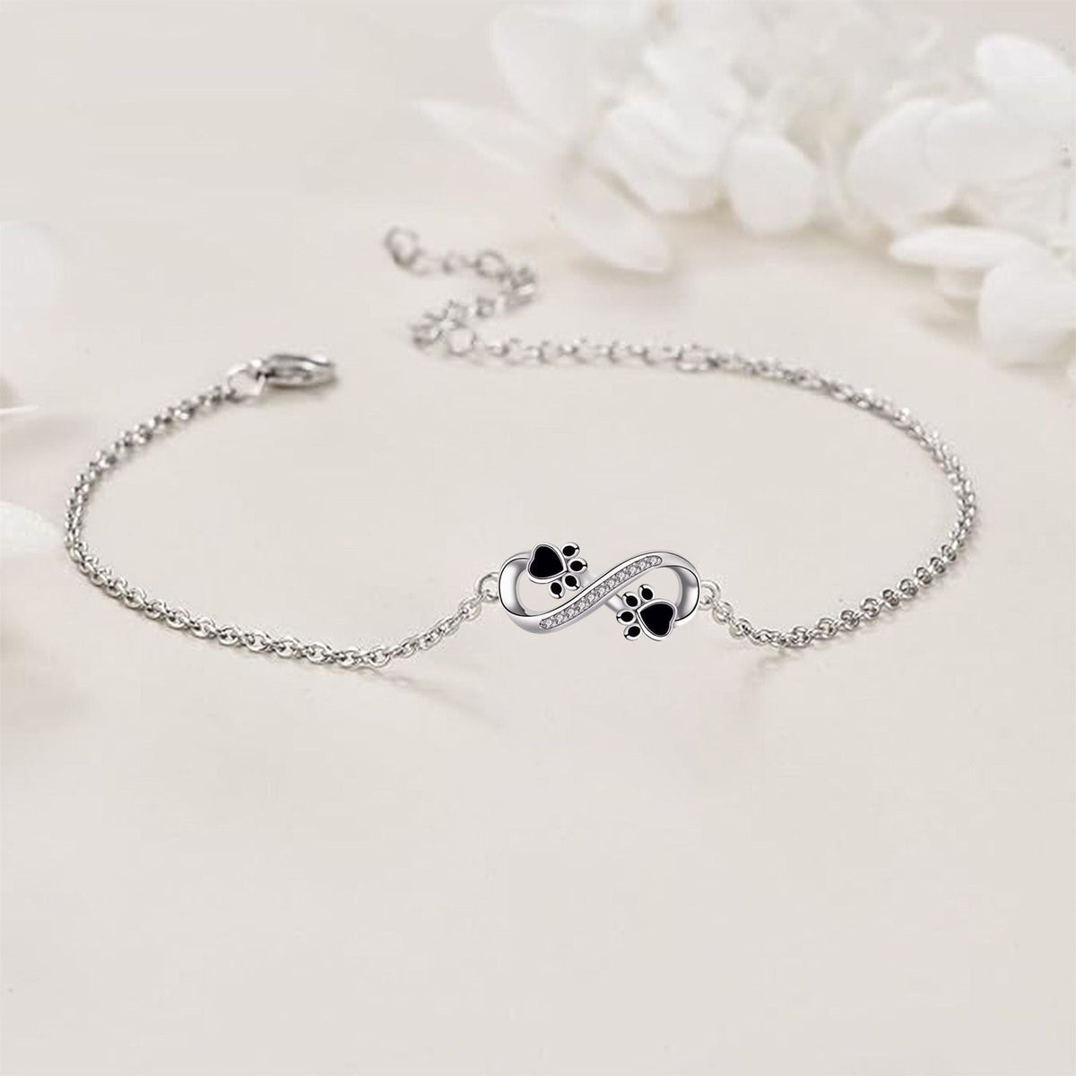 Armband med evighetssymbol, tassberlock och zirkonia