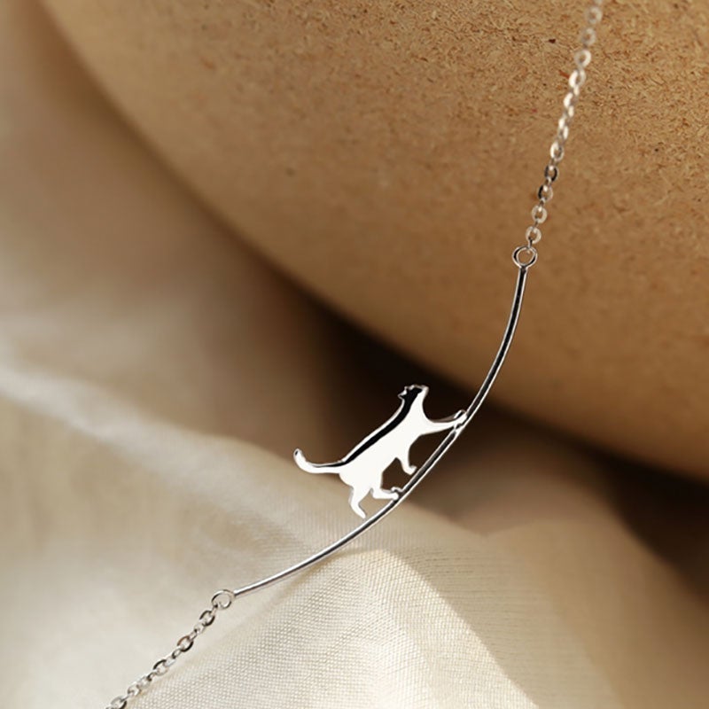 Silverfärgat halsband med klättrande katt