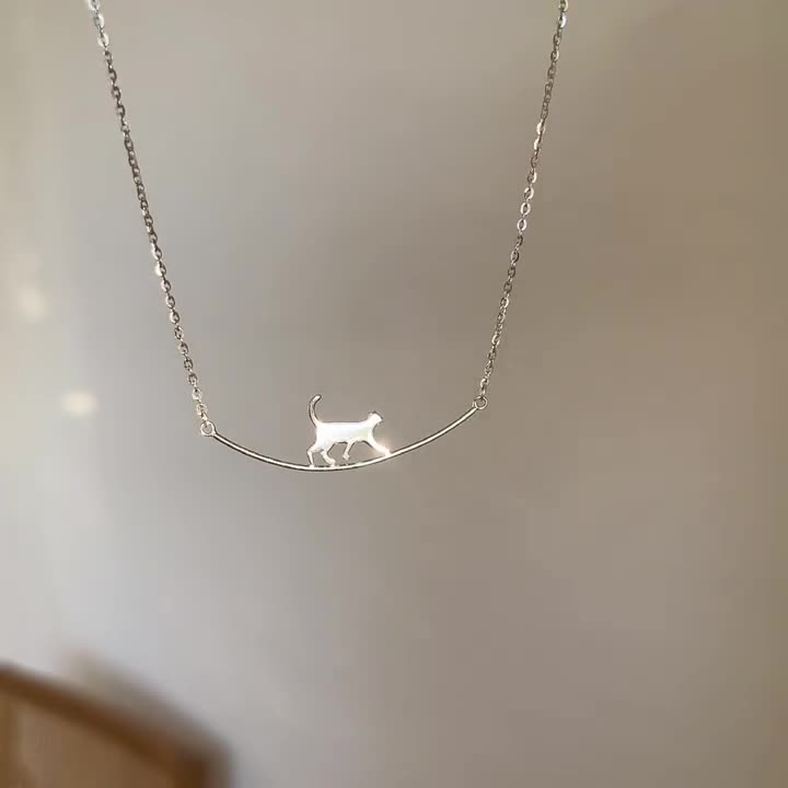 Silverfärgat halsband med klättrande katt